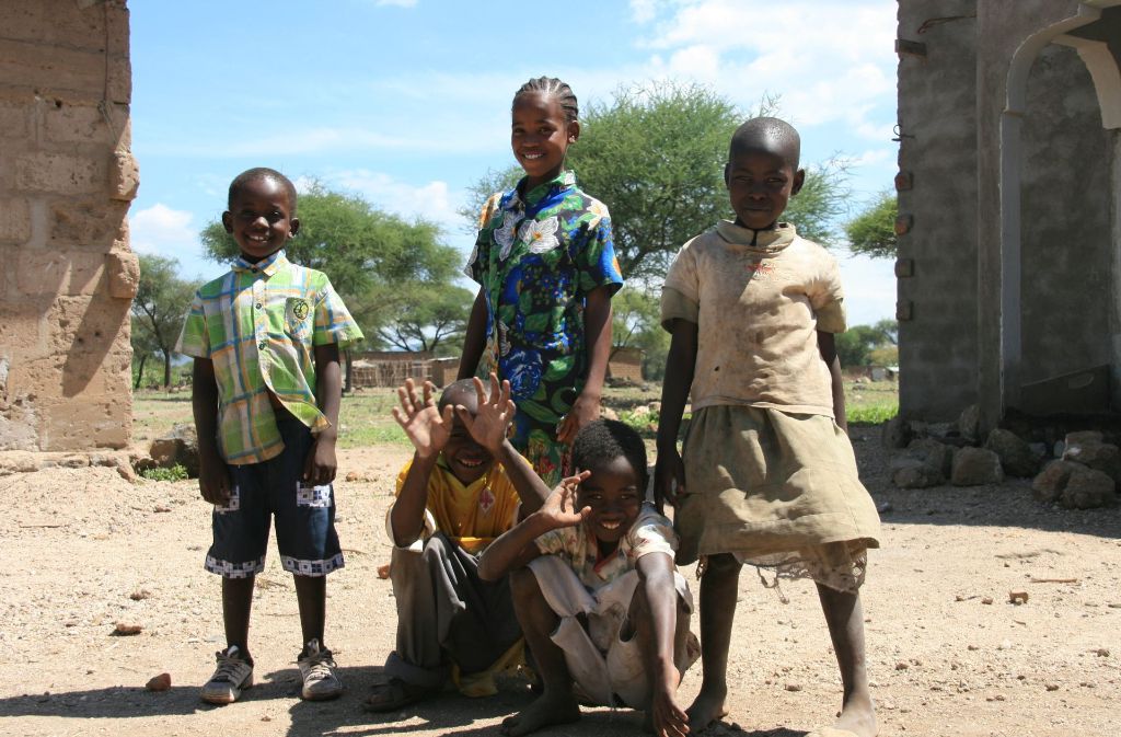 Die damals zehnjährige Ester (Mitte) steht mit ihrem kleinen Bruder Samuel (links) und Nachbarskindern beim Besuch ihres Paten aus Deutschland im Dezember 2008 im Hof ihrer Eltern im Dorf Majengo bei Arusha in Tansania. Hunderttausende Deutsche haben eine Patenschaft für ein Kind in einem ärmeren Land übernommen. Foto: dpa