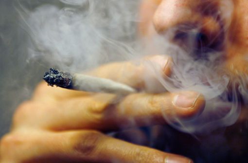 Ein Mann raucht  einen Joint mit Marihuana (Symbolbild). Foto: picture alliance / dpa/Daniel Karmann