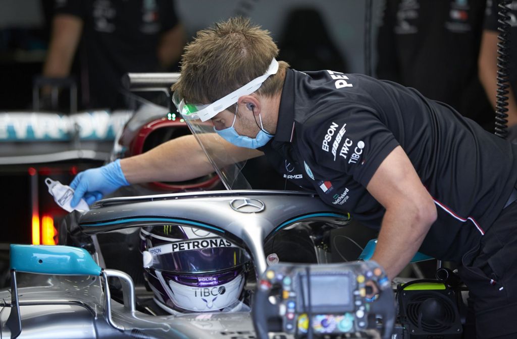 Safety first: Ein Mercedes-Mechaniker reinigt das Visier von Lewis Hamiltons Helm bei des Testfahrten in Silverstone – er trägt ein Gesichtsvisier sowie einen Mund-Nasen-Schutz.