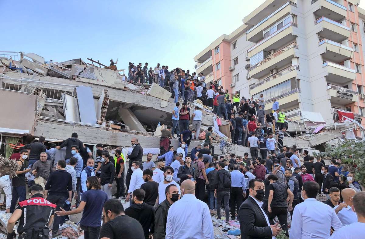 In Izmir versuchen Rettungskräfte und Anwohner, verschüttete Menschen aus einem eingestürzten Gebäude zu retten. Foto: dpa/Ismail Gokmen