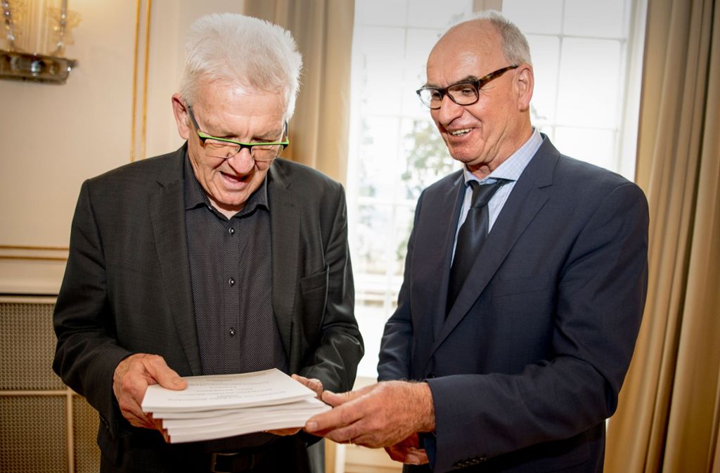 Hubert Klausmann (rechts) von der Uni Tübingen übergibt Winfried Kretschmann  den „Sprachatlas Nord Baden-Württemberg“. Foto: dpa