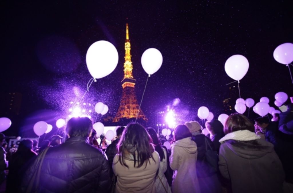 In Japan begrüßen die Menschen das neue Jahr vor dem Tokyo Tower mit Unmengen an Luftballons.