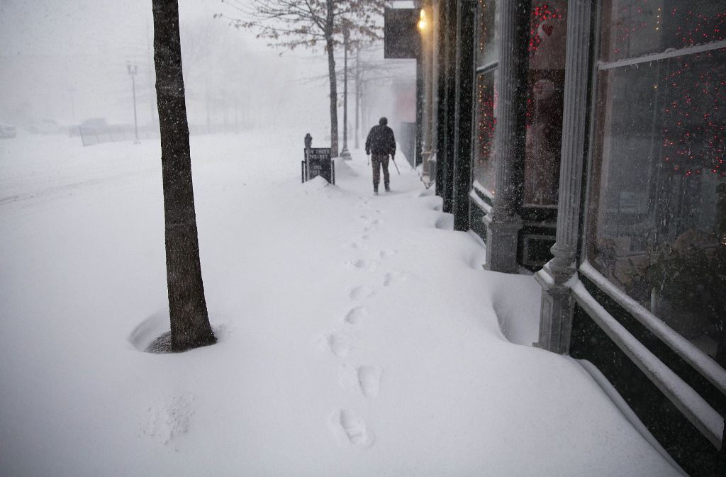 Die Post stellt ihren Betrieb aufgrund der hohen Schneemassen ein. Dieser Fußgänger in Lewiston, Maine, geht trotzdem auf die Straßen.