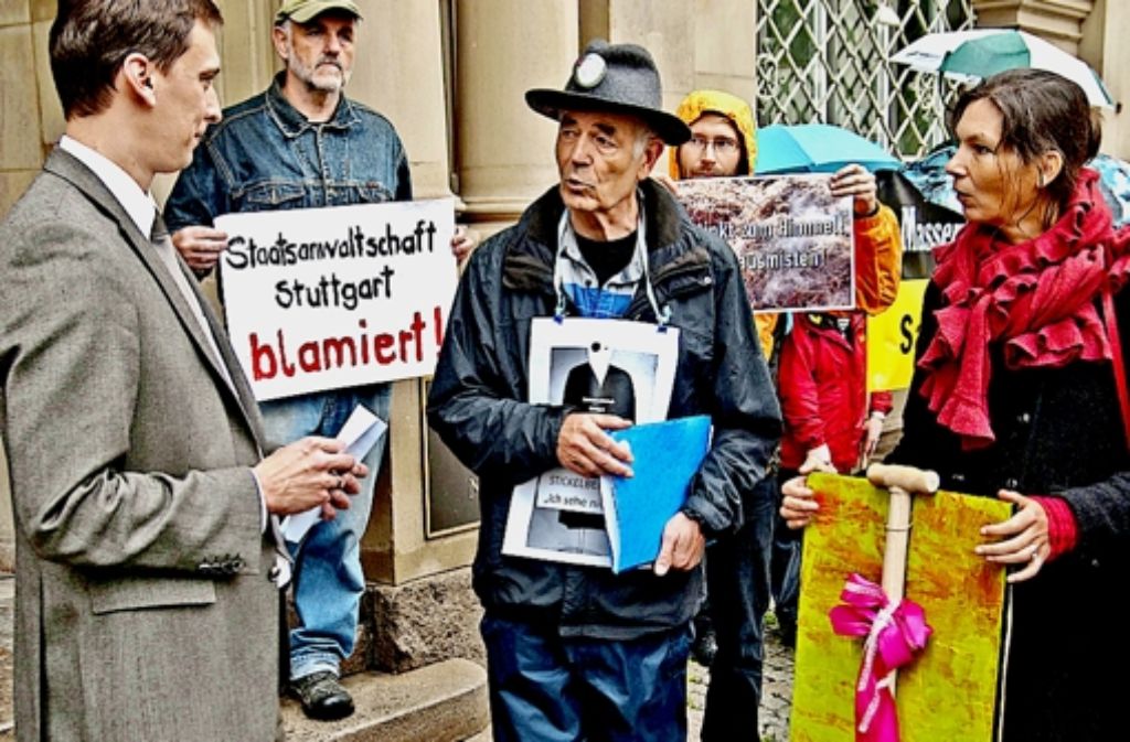 Eine Mistgabel zum Ausmisten bei der Staatsanwaltschaft Stuttgart überreichten die Teilnehmer einer Mahnwache dem Mitarbeiter von Minister Stickelberger (links). Foto: Jens Volle