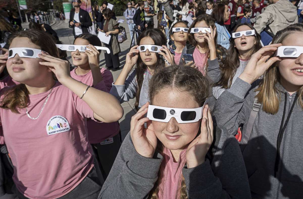Jugendliche in Serbien schauten sich mit Sonnenbrillen das Spektakel an.