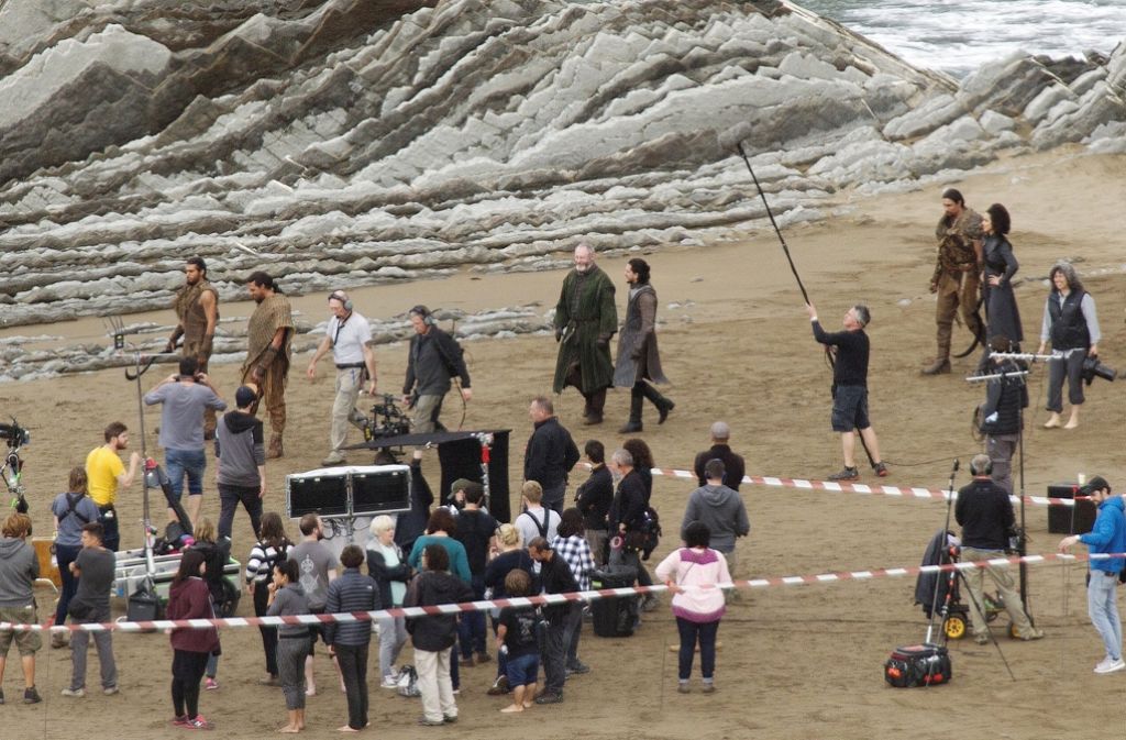Auf diesem Bild der Dreharbeiten läuft Jon Snow (Mitte) mit Ser Davos, Missandei (hinten rechts) und einigen Dothraki-Kriegern einen Strand entlang.