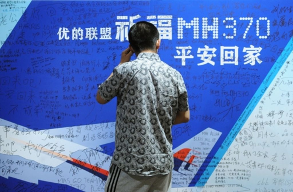 Die meisten Passagiere kamen aus China: Hier schaut ein Mann auf eine großflächige Anzeige, auf die Unterstützer aufmunternde Worte geschrieben haben.