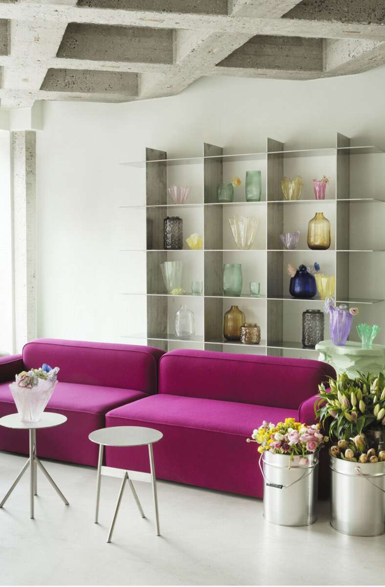 Pfingstrosig sieht es bei Normann Copenhagen aus: Blick auf ein pinkfarbenes Sofa und gefärbte Gläser – ein weiterer Trend des Jahres 2022.