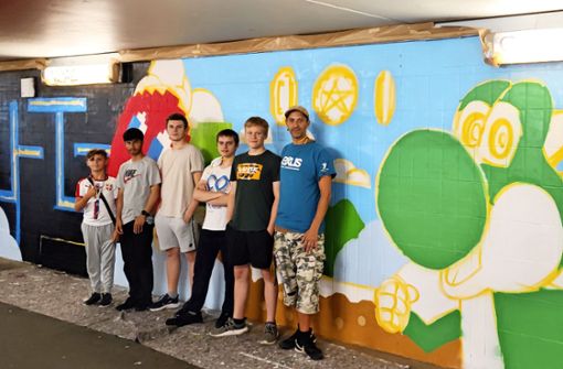 Die Jugendlichen und der Jugendhausleiter  Kim-Simon Stelzig (rechts) sind stolz auf ihr farbenfrohes Kunstwerk in der Unterführung. Foto: Robin Kern