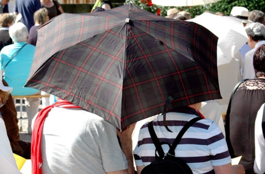 Donnerstag, 10.44 Uhr – Der Klassiker – hilft bei Regen und bei Sonne. Um sich vor den gleißenden Strahlen zu schützen, greifen viele der Besucher zum Regenschirm. So können sie halbwegs ungestört den Gottesdiensten lauschen.