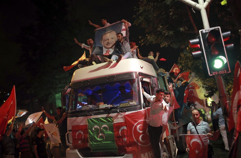 Anhänger des türkischen Präsidenten Erdogan jubeln vor der Partei-Zentrale der islamisch-konservativen Partei AKP in Istanbul und sitzen auf einem Lastwagen.