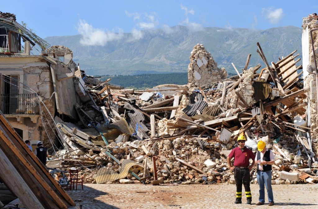 L’Aquila (Italien): Helfer stehen am 7. Juli 2009 in dem stark zerstörten Dorf Onna nahe der italienischen Stadt L’ Aquila nach dem schweren Erdbeben.