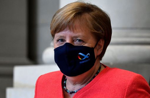 Angela Merkel trägt eine  schwarze Maske mit dem Logo der deutschen EU-Ratspräsidentschaft. Foto: AFP/JOHN MACDOUGALL