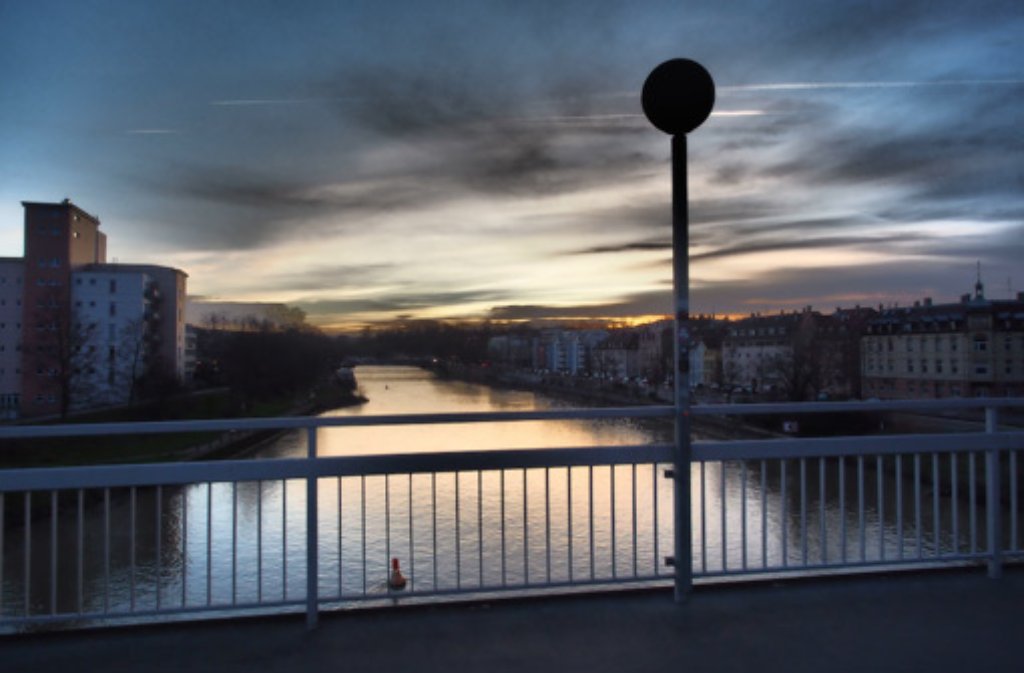 Blick vom Cannstatter Mühlsteg: Die letzten Sonnenstrahlen glänzen hell auf der Wasseroberfläche des Neckars.