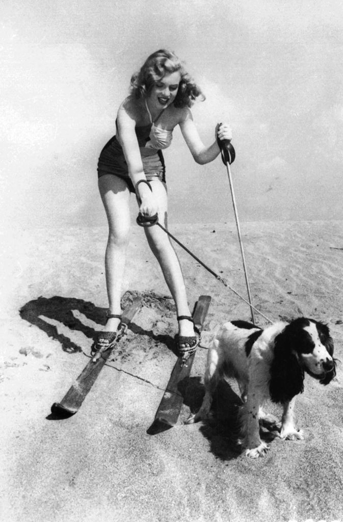 Noch einmal die junge Marilyn am Strand mit Skiern und Hund. Geboren wurde sie am 1. Juni 1926 in Los Angeles als Norma Jeane Mortenson, ihr Taufname lautete später Norma Jeane Baker.