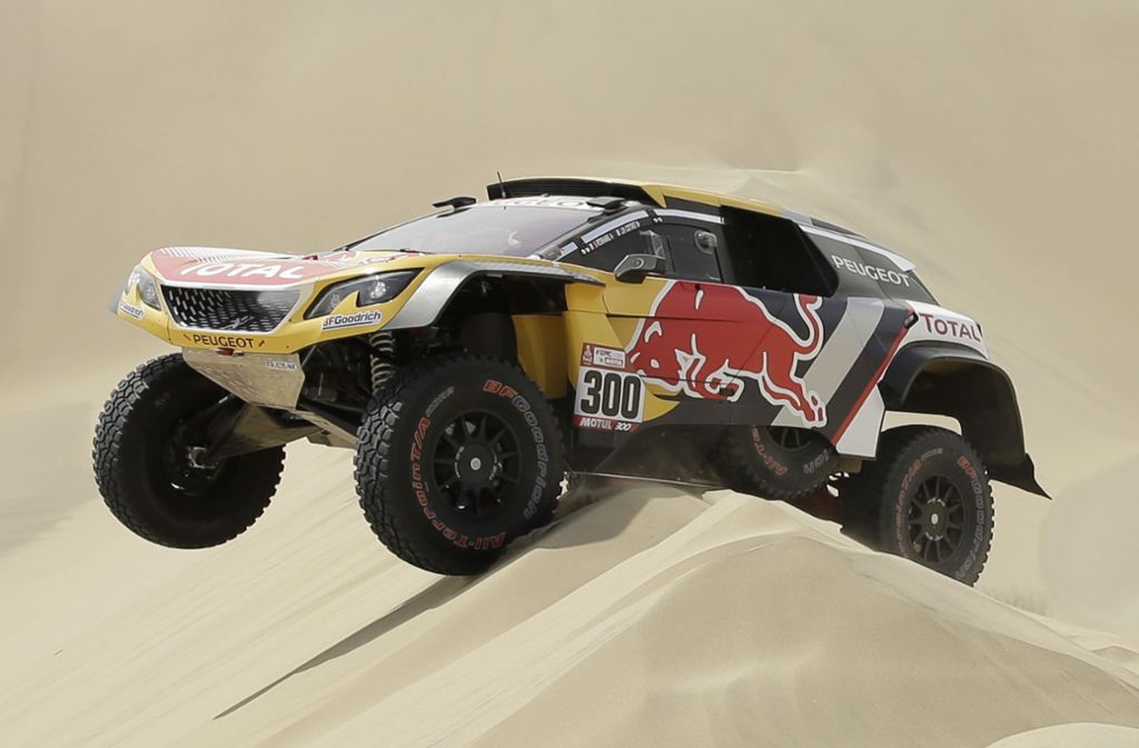 Hoch das Beinchen: Stephane Peterhansel manövriert seinen Peugeot sicher über eine der tückischen Sanddünen.