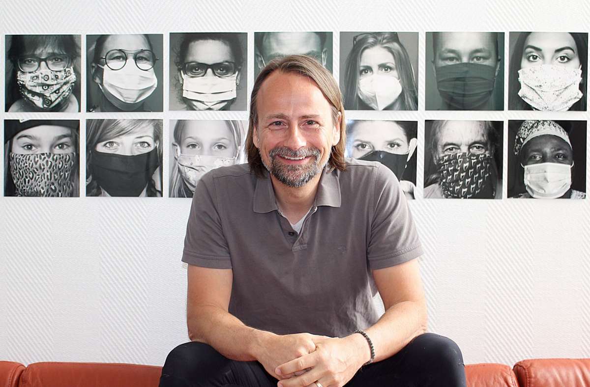 Markus Schwarz vor Porträts mit Masken