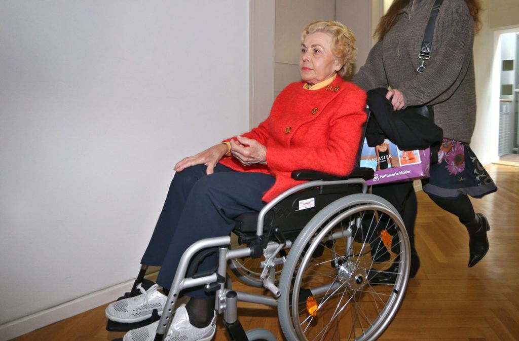 Ingrid Millgramm wird von einer Betreuerin in einem Rollstuhl sitzend in das Landgericht geschoben.
