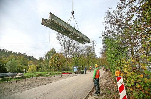 Seit August werden Arbeiten an der Brücke zur Neckarinsel in Oberesslingen vorgenommen. Nun wird der Steg mit Hilfe von Spezialmaschinen abgebaut. Foto: Roberto Bulgrin
