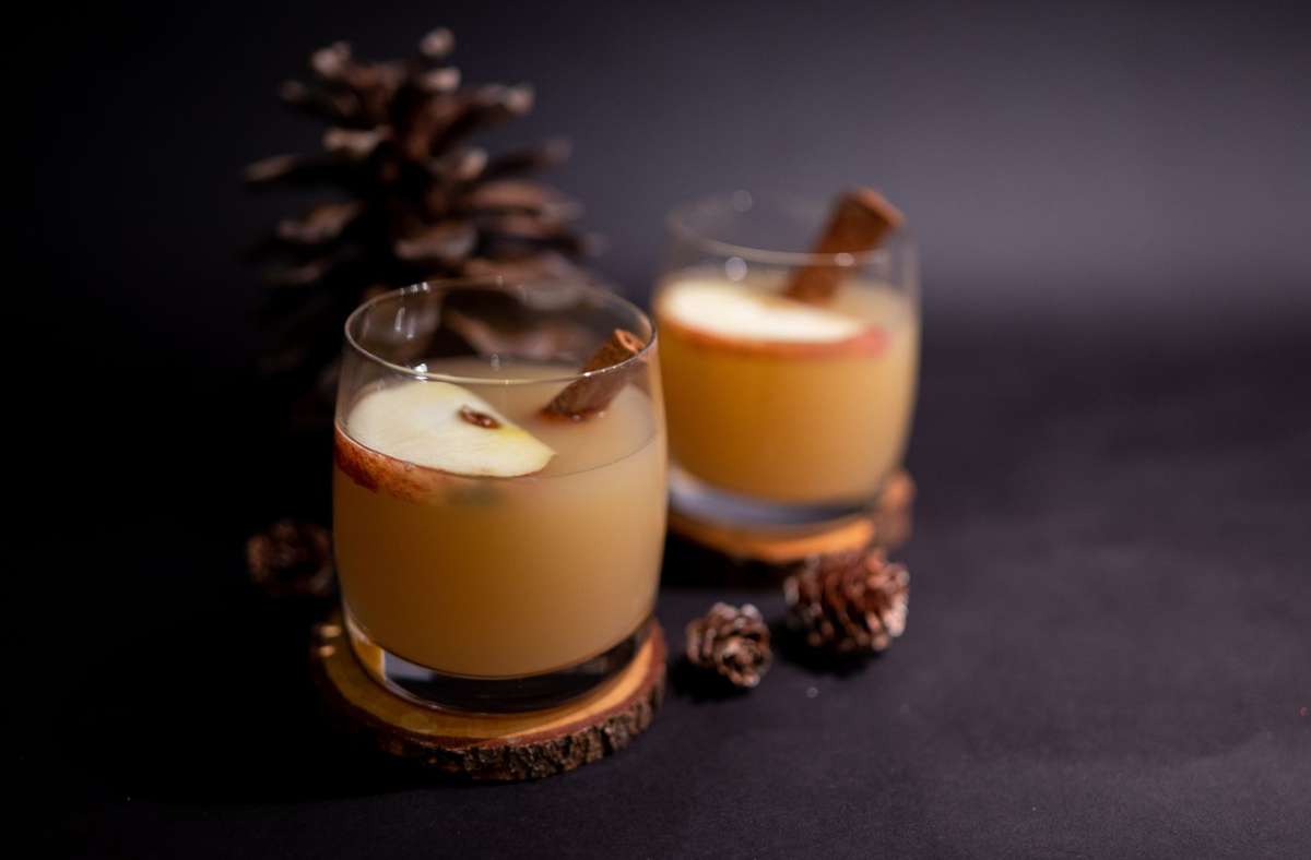 Den Saft im Topf erwärmen. Zwei bis drei Zentiliter Gimber in ein Glas geben – je nach Geschmack. Mit dem Saft auffüllen und mit einer halben Apfelscheibe und einer Zimtstange dekorieren.