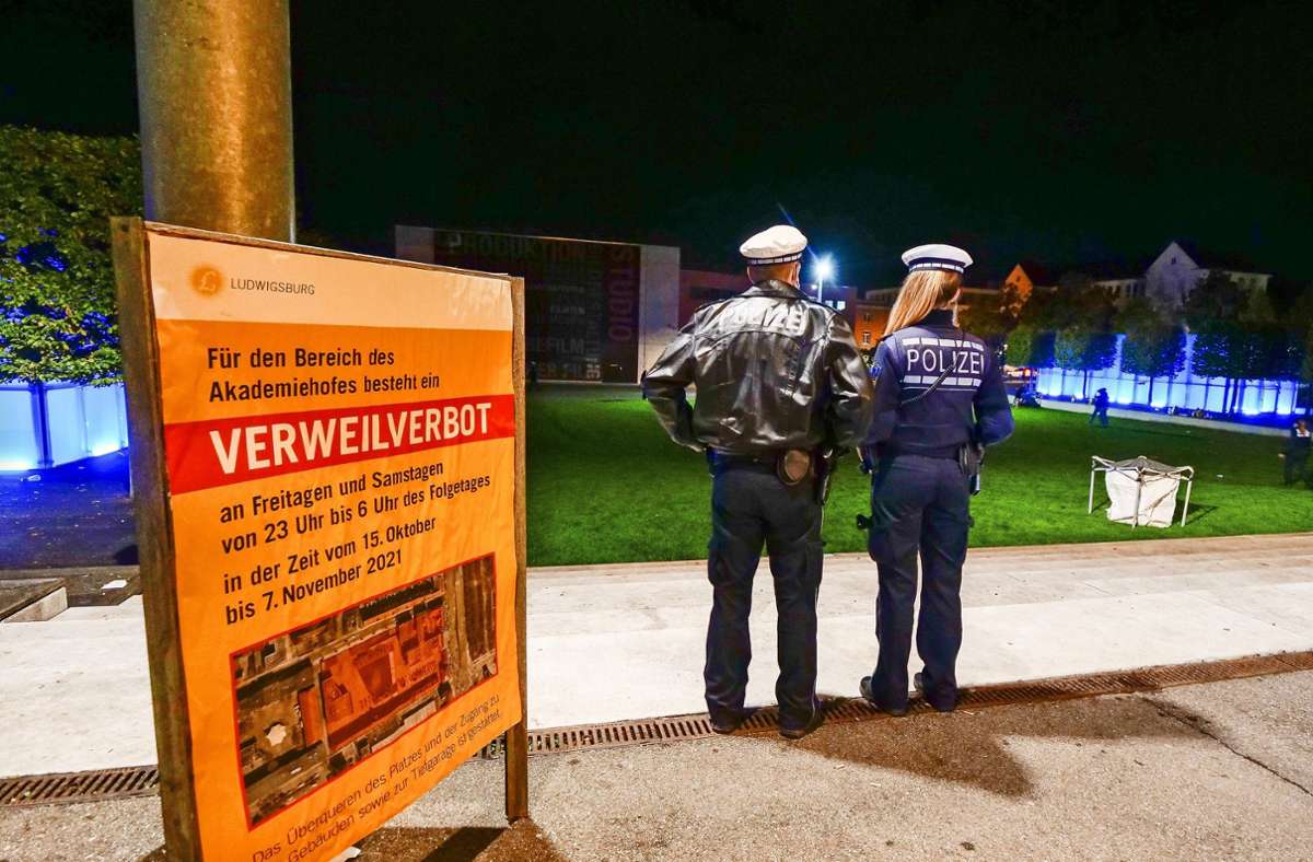Zwei Polizeibeamte überblicken am Freitagabend den menschenleeren Akademiehof,...