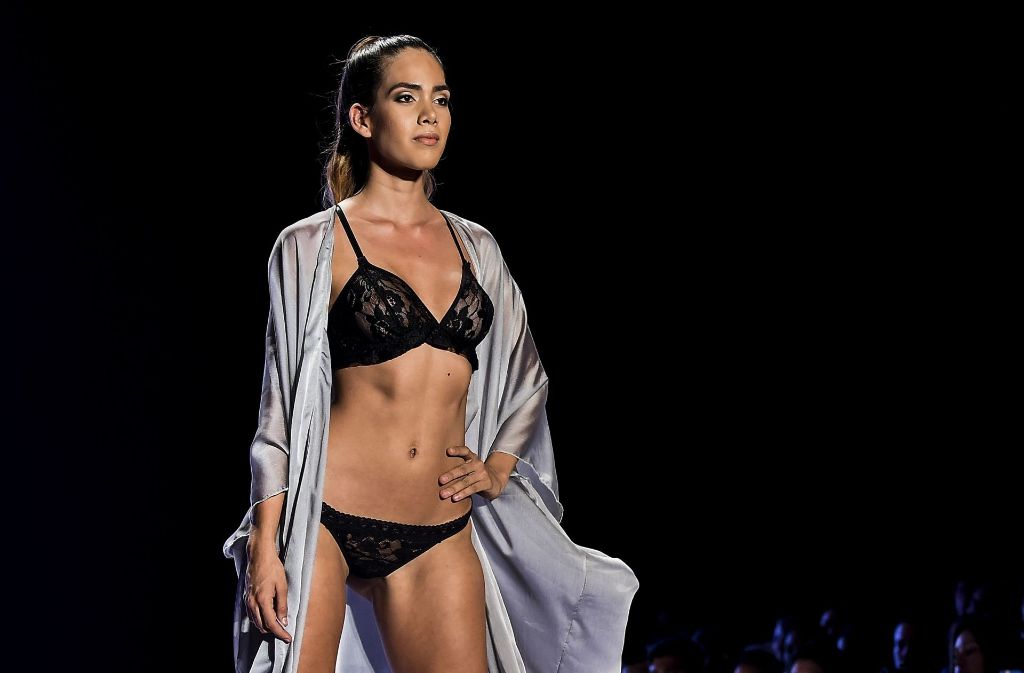 Ein Model präsentiert in Kolumbien Dessous aus schwarzer Spitze mit einem edlen Morgenmantel aus Seide während der Cali Exposhow Fashion Week.