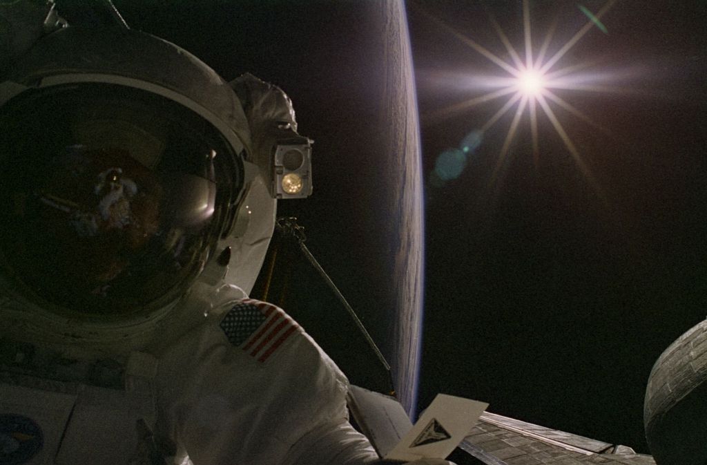 Die Sonne strahlt über den Erdhorizont – und ein Astronaut schaut zu. Aufnahme von der Internationalen Raumstation ISS.