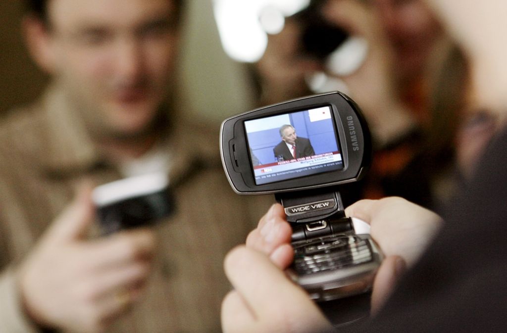 Journalisten begutachten 2006 in Stuttgart Samsung-Mobiltelefone, auf denen mobiles Fernsehen zu sehen ist. In fünf deutschen Großstädten war künftig der Fernsehempfang auf dem Handy möglich.