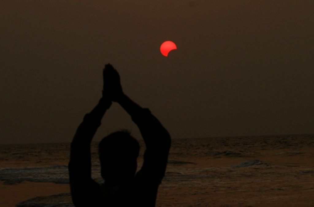 Ein indischer Fischer betet während der Sonnenfinsternis.