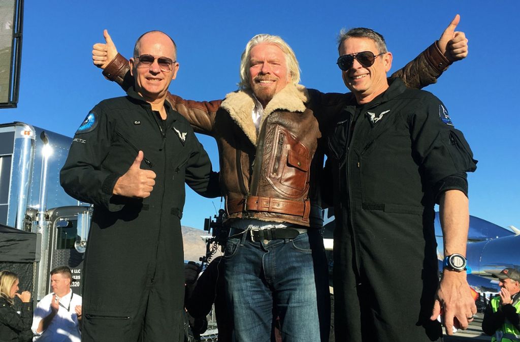 Richard Branson (Mitte), Gründer von Virgin Galactic, gratuliert den Piloten Rick Sturckow (links) und Mark Stucky zu ihrem erfolgreichen Testflug mit dem Tourismus-Raumschiff „VSS Unity“ von Virgin Galactic. Es hatte bei dem Testflug eine Höhe von etwa 82 Kilometern erreicht.