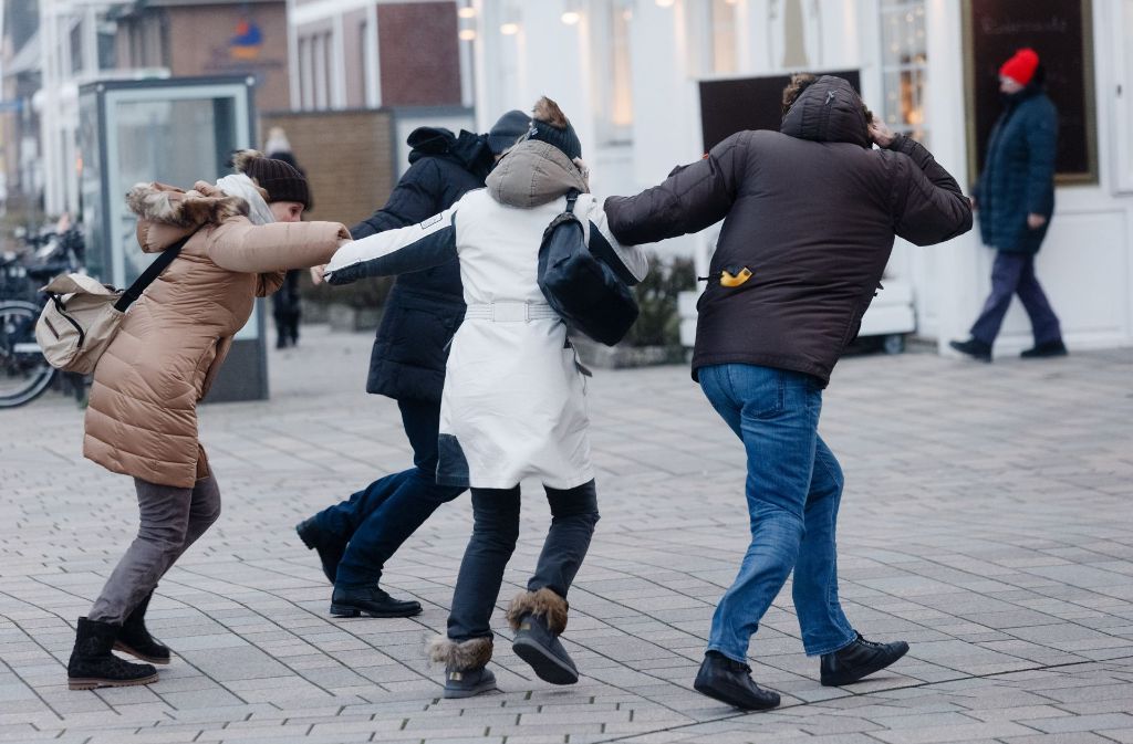 Nicht jeder nimmt den Sturm mit Humor: Fußgänger kämpfen in Westerland auf Sylt gegen den Wind an.