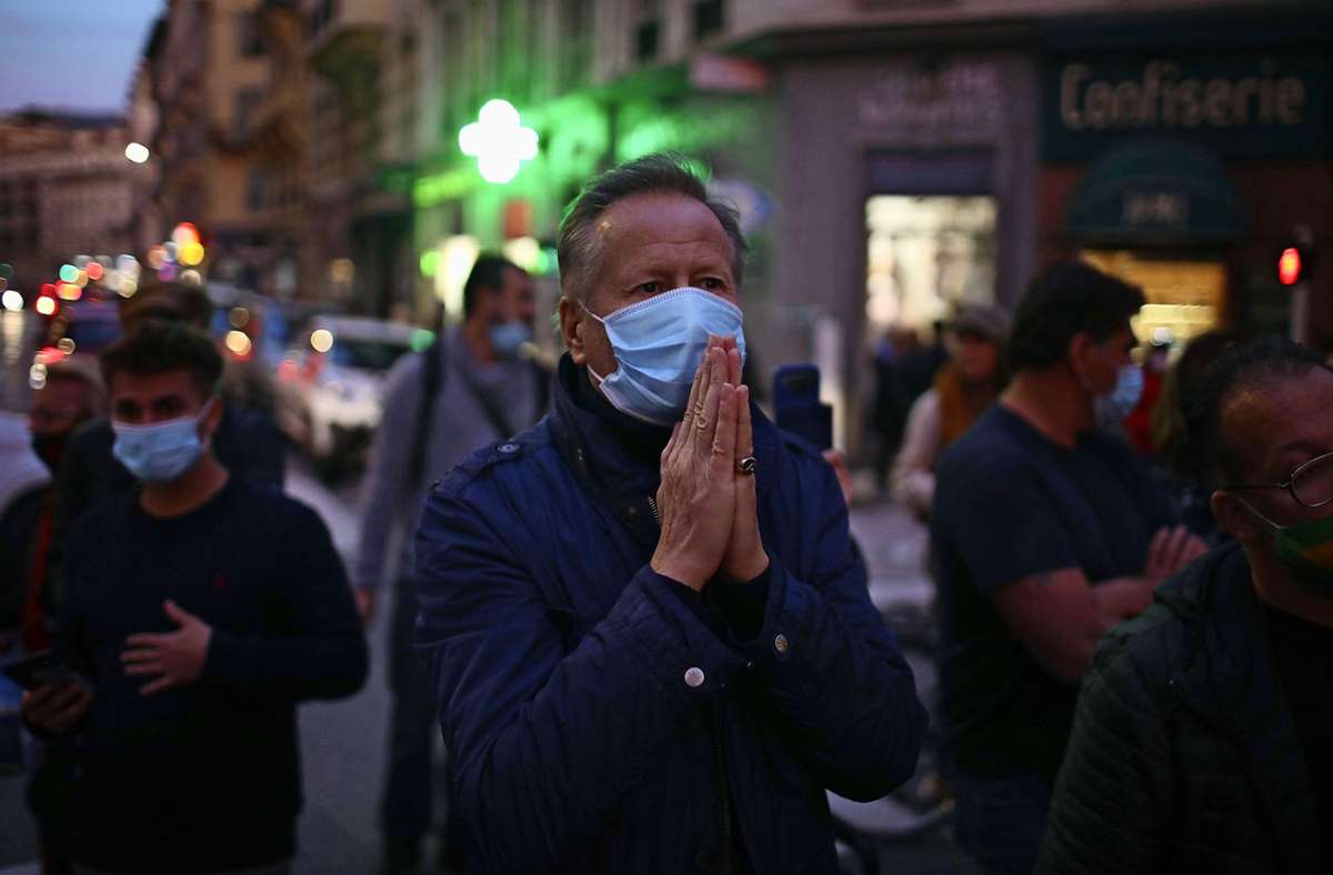 Ein Mann betet auf der Straße vor dem Tatort in Nizza. Foto: dpa/Daniel Cole
