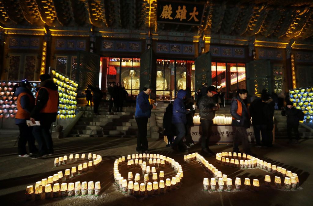 Südkorea, Seoul: Während der Neujahrsfeiern im buddhistischen Jogyesa-Tempel zünden Menschen Kerzen in Form der Zahl 2019 an.