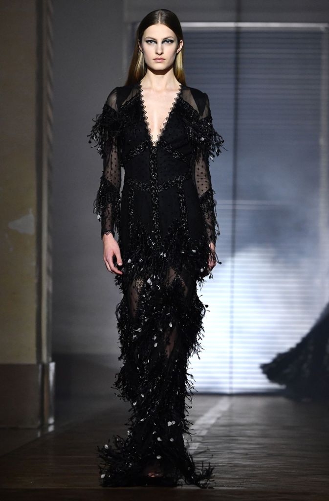 Elegant und sexy zugleich: Givenchy setzt im schwarzen, bodenlangen Kleid Akzente mit durchsichtigen Elementen zu Fransen und Pailleten.