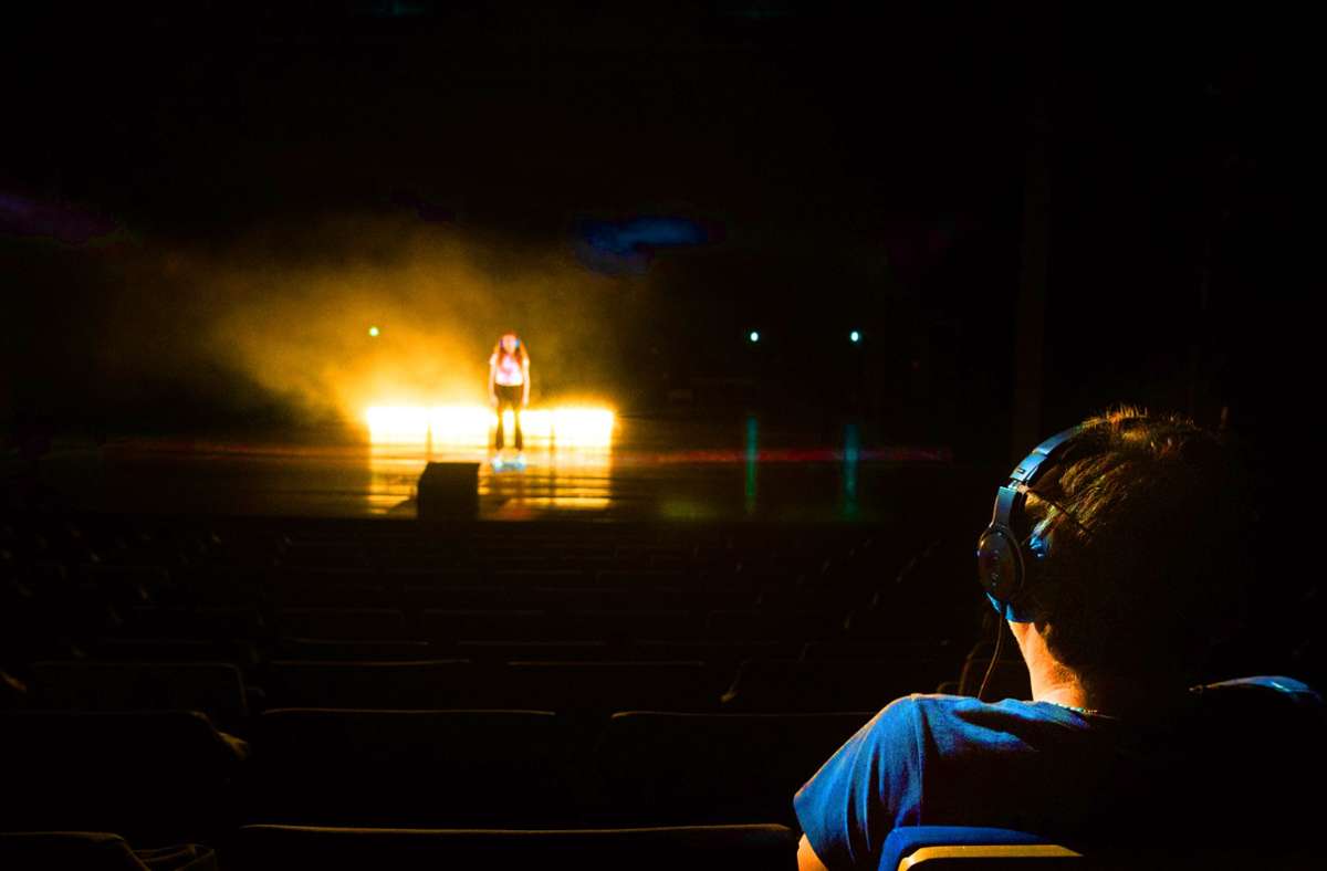 Der  Zuschauer   als Mitmacher: Ein Teilnehmer des Theaterparcours  „Black Box“ von Rimini Protokoll sitzt im Saal und  einer steht auf der Bühne. Text hören beide via Kopfhörer. Foto: Björn Klein