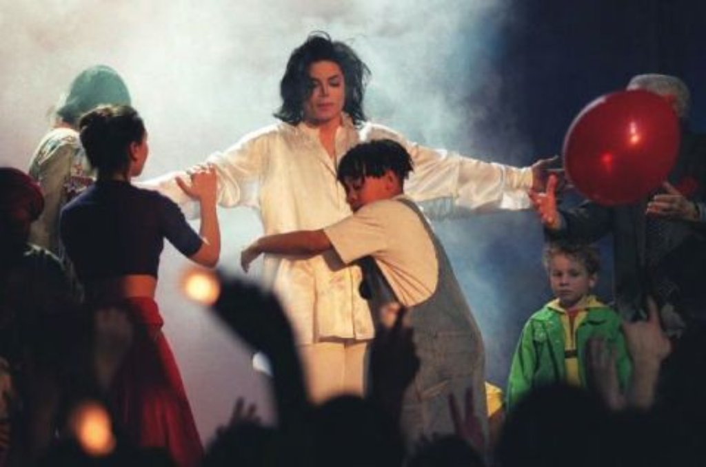 Von Kindern umringt singt der US-Popstar anlässlich der Verleihung der Brit Awards in London 1996 seinen "Earth-Song". Drei Jahre zuvor war Jackson wegen Kindesmissbrauchs angeklagt worden. Zum Prozess kam es damals nicht. Jackson zahlte stattdessen einen Millionen-Betrag an die Eltern des Kindes, die die Klage daraufhin zurückzogen.