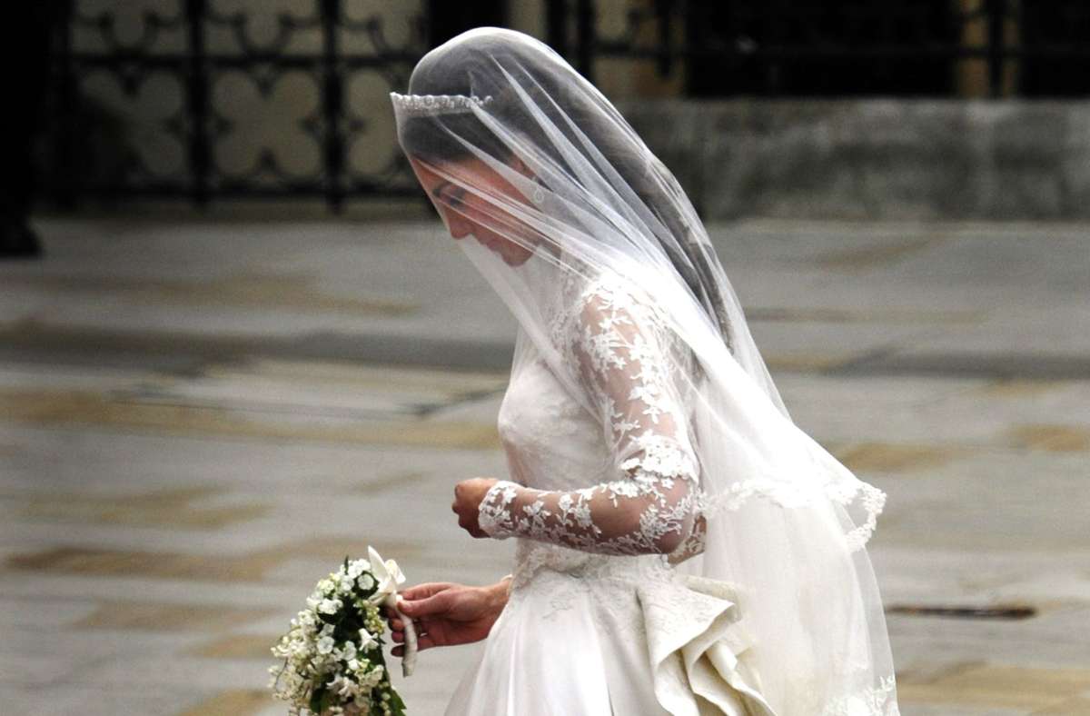 Da blieb den Zuschauern die Spucke weg: Kate Middleton entschied sich bei ihrem Brautkleid für den britischen Stardesigner Alexander McQueen. Die Robe war ein standesgemäßer Traum: elfenbeinfarben, lange Ärmel aus Spitze, V-Ausschnitt, schmale Silhouette mit weitem Rock.