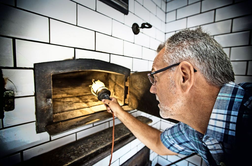 Werner Huber wirft einen prüfenden Blick in den altersschwachen Ofen