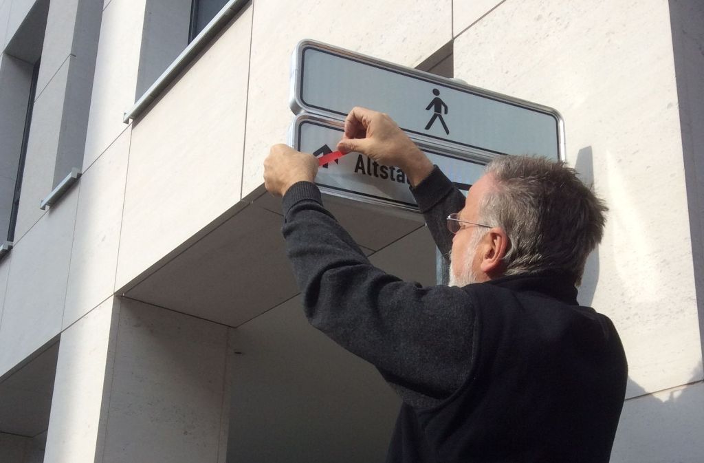 Peter Mielert legt selbst Hand, um das Schild zu korrigieren.