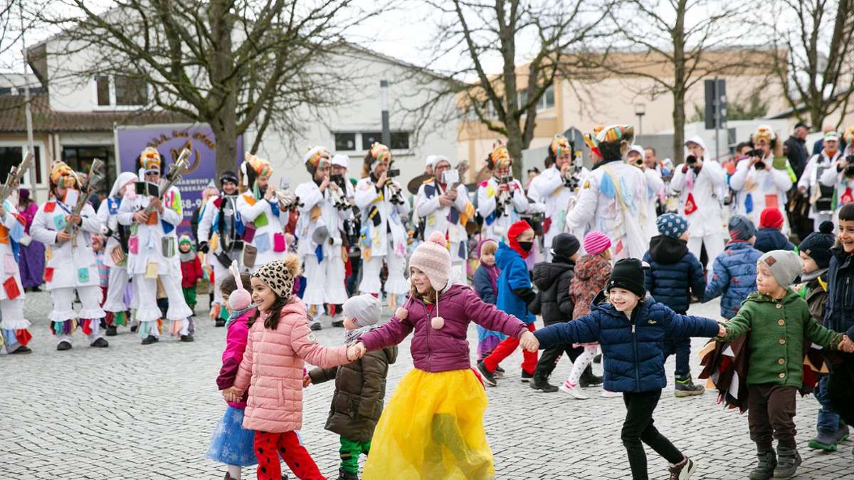 Die Kinder aus den Neuhausener Kitas tanzen auf dem Kirchplatz zur Guggnmusik.