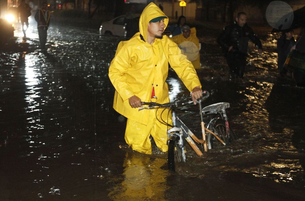 Ein Mann watet mit seinem Fahrrad durch das Wasser (6. September).