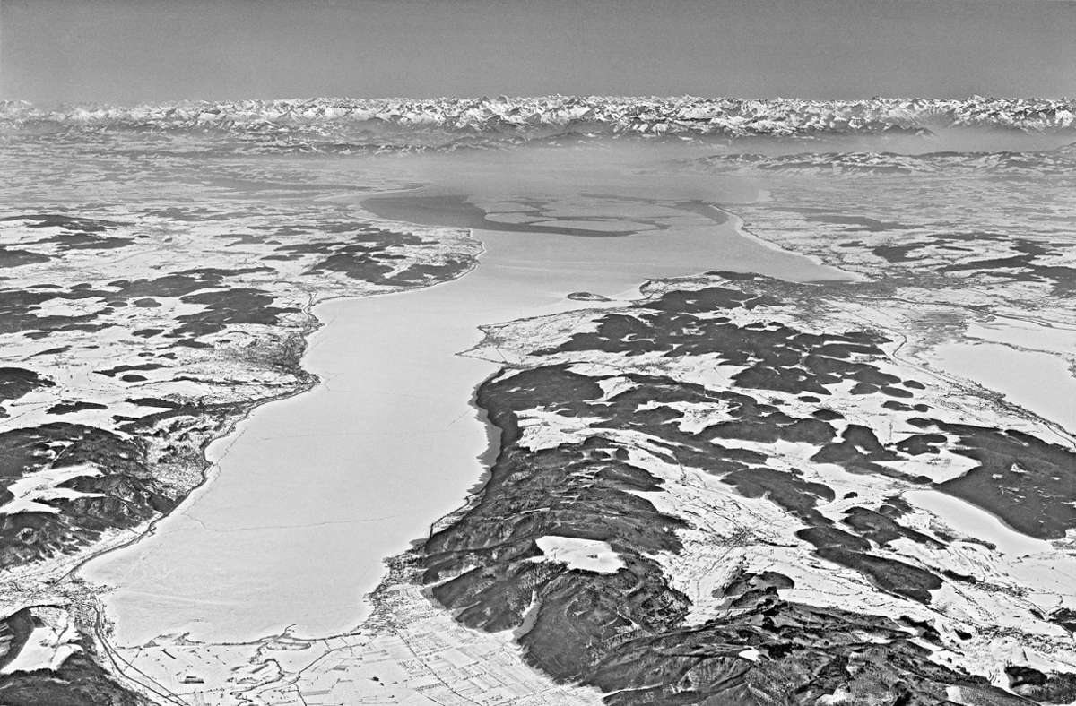 Ein historischer Moment, auf Fotopapier eingefroren: Blick vom Westende des Überlinger Sees über den zugefrorenen Bodensee. Die Mainau ist zu erkennen, darüber die Alpenkette.