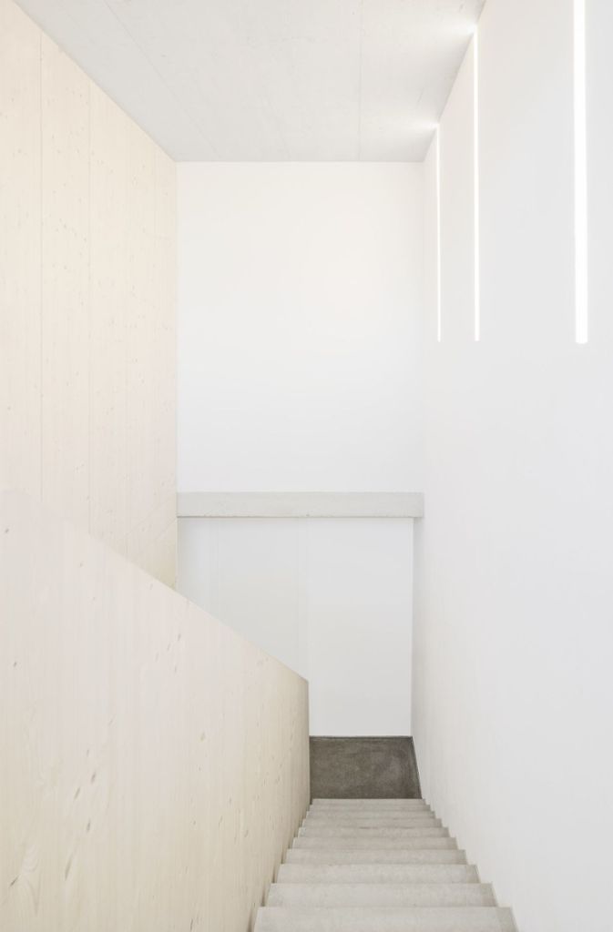 Blick auf die Treppe vom obersten Geschoss aus – mit in die Wand eingelassenen Leuchtrohren.