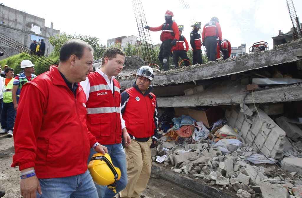 Mauricio Rodas (Mitte), der Bürgermeister von Quito, sieht sich das Ausmaß der Zerstörung genauer an.