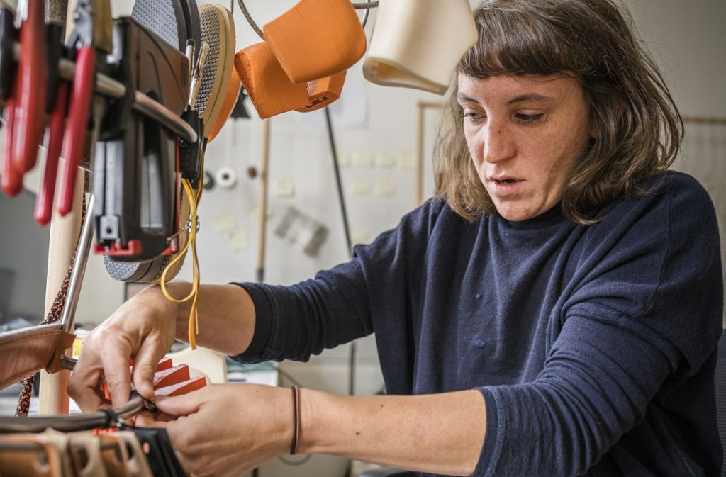 Guggenberger hat in ihrem Studio eine Werkstatt eingerichtet. An Holzgestängen hängen Werkzeuge, Leder, Holzmodelle. Die Tür zum Studio ist meist offen. Man soll ihr zusehen: „Die Produktion findet ansonsten ja nur noch hinter verschlossenen Türen statt. Niemand weiß, wie ein Schuh gemacht wird“, sagt sie.