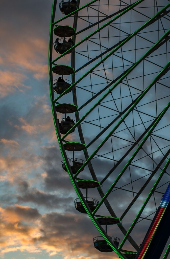 Prächtiges Farbenspiel am Himmel: Das grüne Riesenrades leuchtet mit dem orange-blauen Himmel um die Wette.