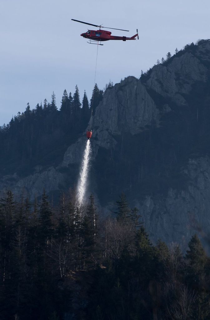 Ein anderer Helikopter löscht einen Brandherd am Jochberg.