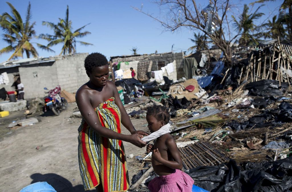 Eine Mutter sieht in Beira ihre Tochter neben den Trümmern ihres Hauses an.