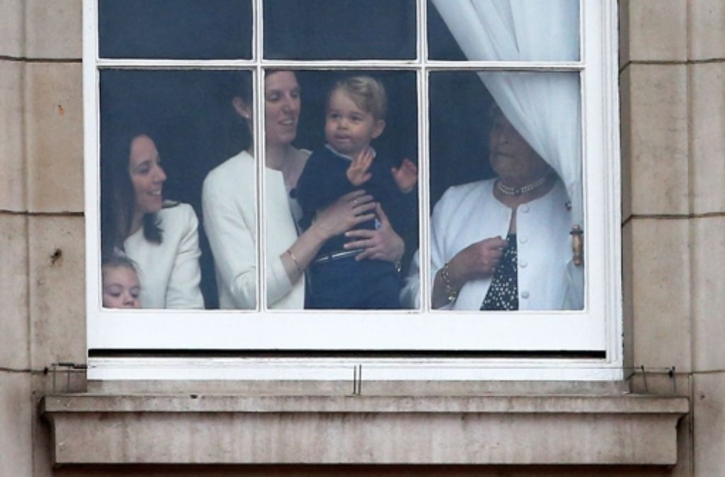 Kates und Williams Sohn, der kleine Prinz George, verfolgt die Parade vom Fenster des Buckingham Palasts aus.