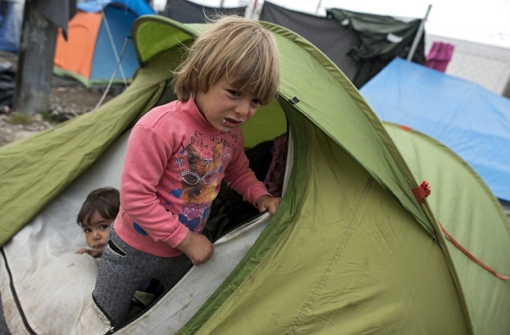 Flüchtlingskinder schauen aus ihrem Zelt im Zeltlager an der griechisch-mazedonischen Grenze.
